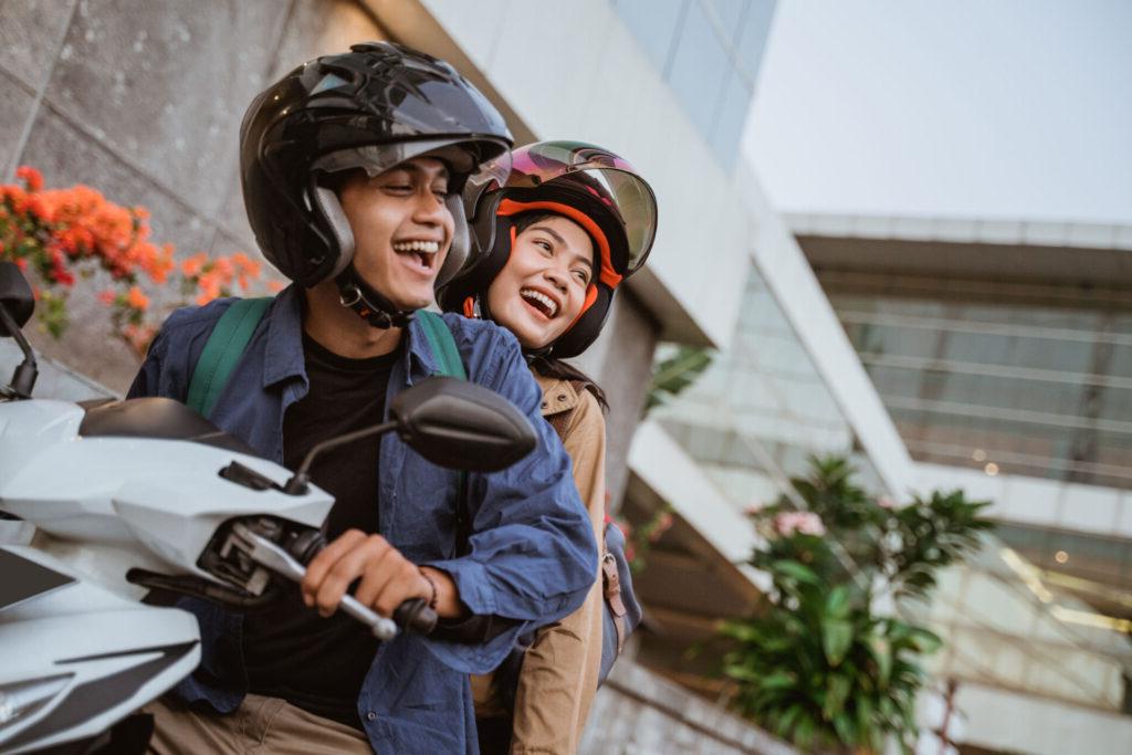 Using their credit union vehicle loan, a happy couple rides off in their new motorcycle.